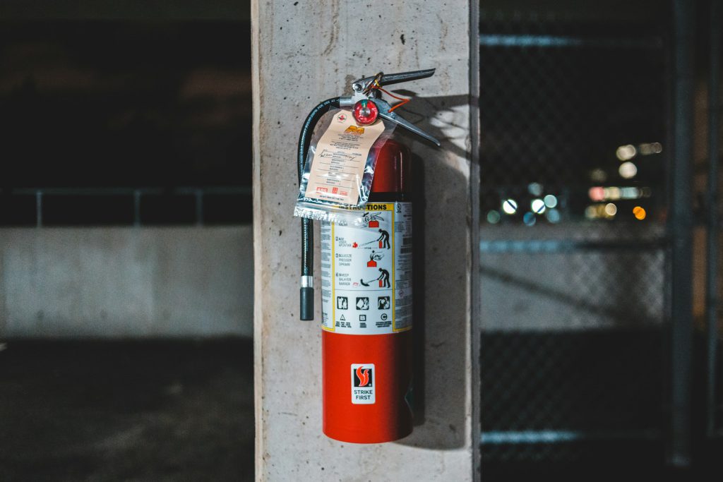 red safety fire extinguisher mounted on wall