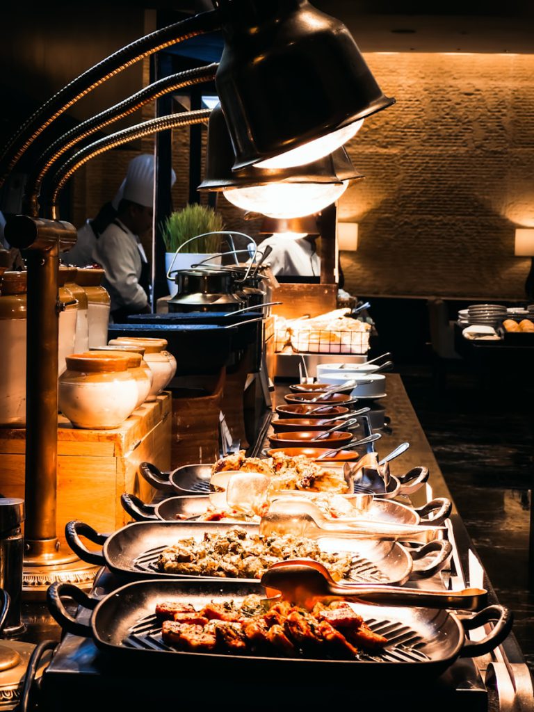 a buffet table with roast meats and other plates of food on it